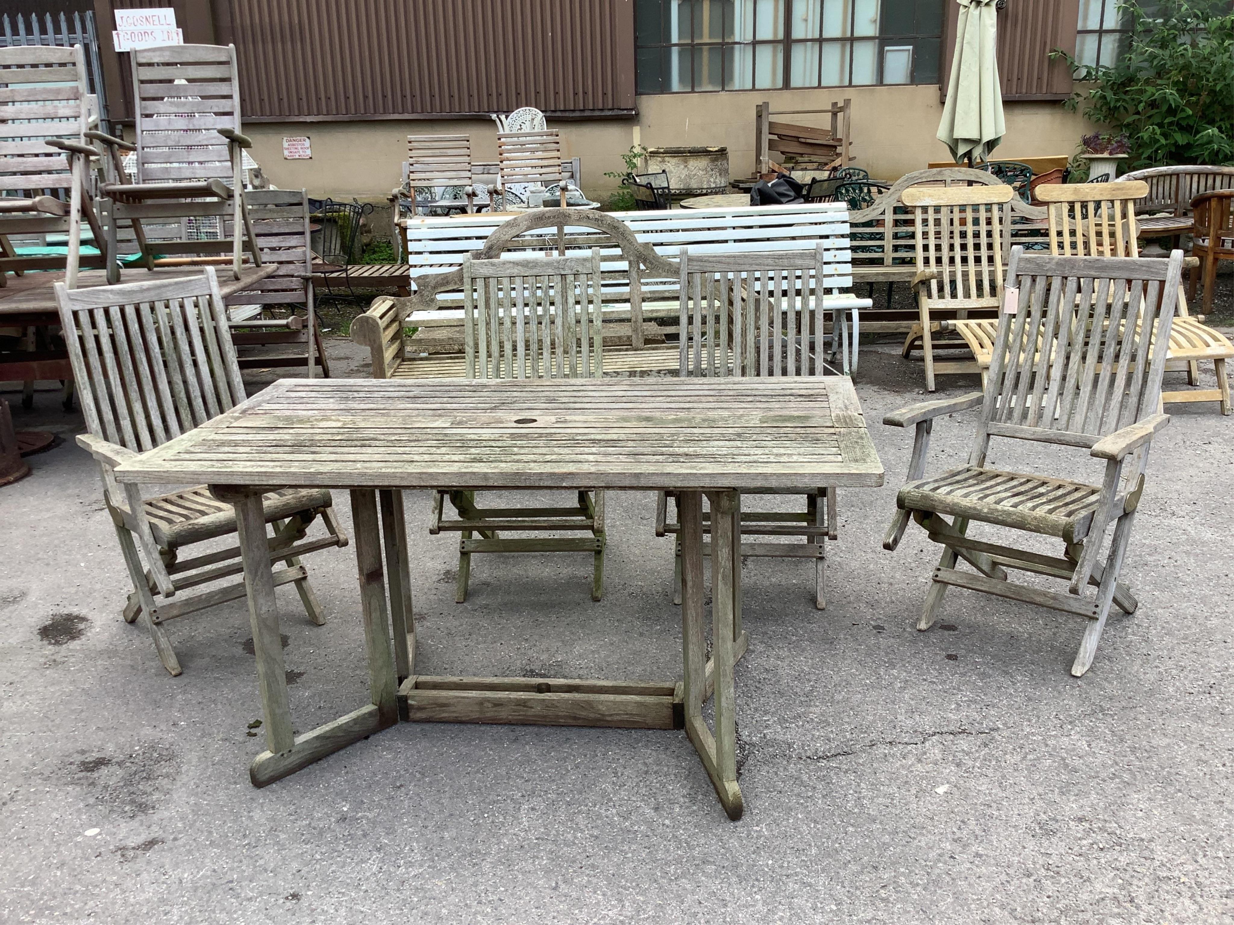 A weathered teak rectangular folding garden table, width 157cm and four folding chairs
